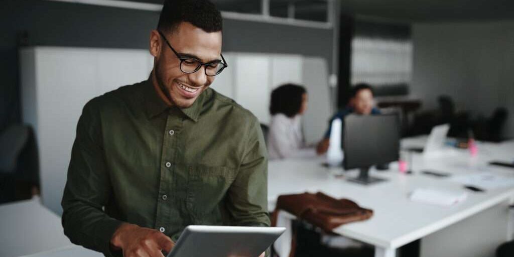 Image depicts a person reviewing the 2023 SaaS trends on a tablet.