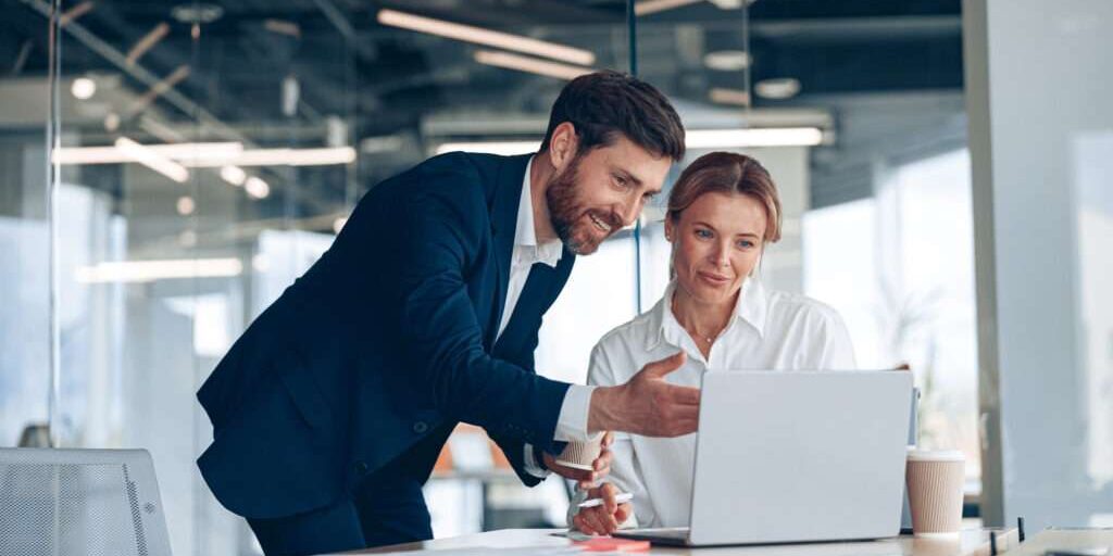 Image depicts two employees reviewing their spend management